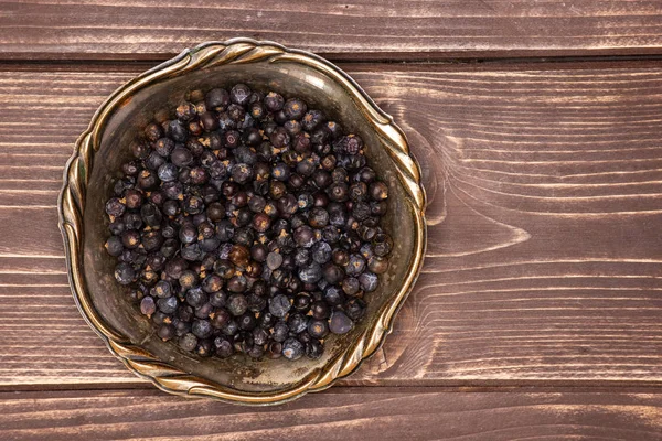 Dry juniper berries on brown wood