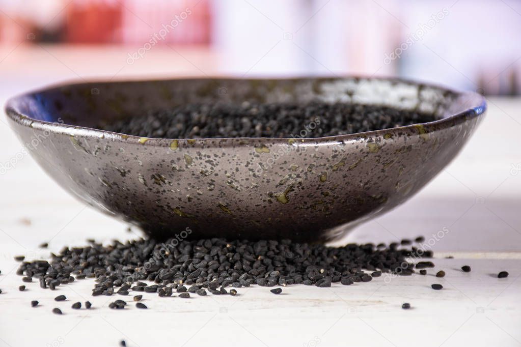 Black cumin seeds with kitchen behind