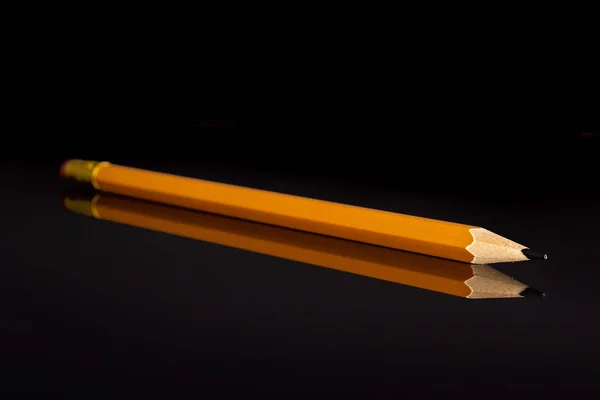 Lápiz amarillo simple aislado en vidrio negro — Foto de Stock