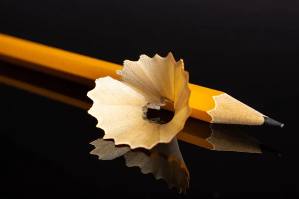 Gelber einfacher Bleistift isoliert auf schwarzem Glas — Stockfoto