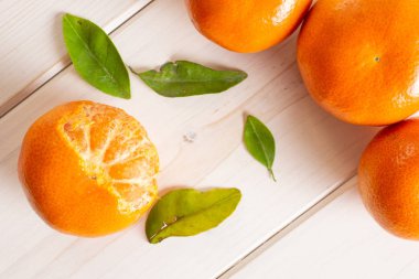 Gri ahşap üzerinde bir yaprak ile Mandarine