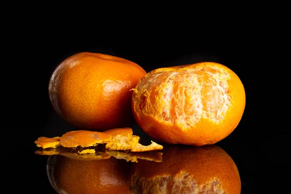 Mandarina con una hoja aislada en vidrio negro —  Fotos de Stock