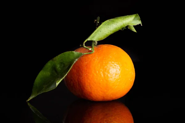 Mandarine with a leaf isolated on black glass — Stock Photo, Image