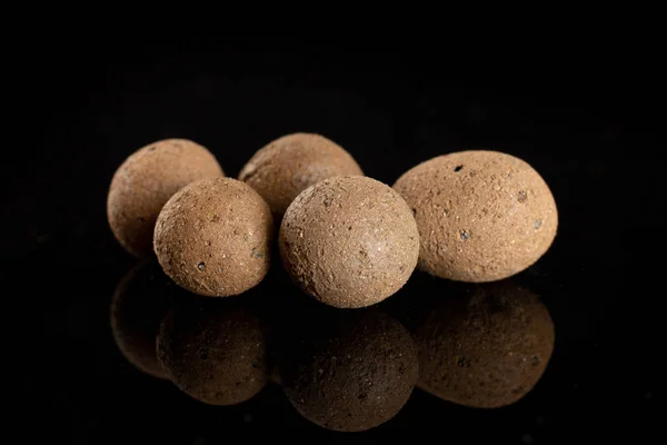 Clay pebbles (leca) isolated on black glass