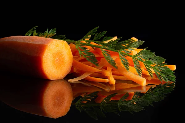Fresh orange carrot isolated on black glass