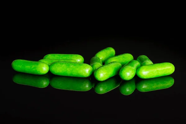 Licorice sweet comfit isolated on black glass