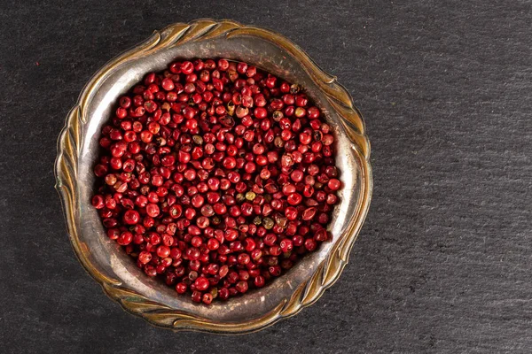 Pink peruvian pepper on grey stone