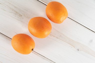 Gri ahşap üzerinde taze turuncu kayısı