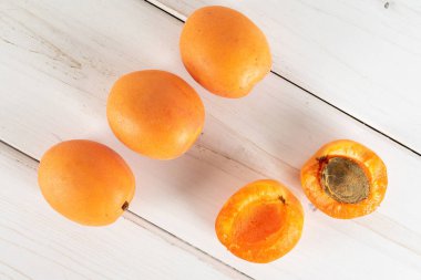 Gri ahşap üzerinde taze turuncu kayısı