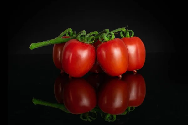Tomate cereja vermelho isolado em vidro preto — Fotografia de Stock