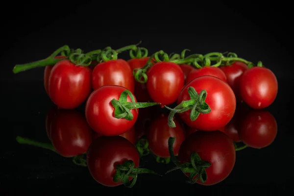 Rote Kirschtomate isoliert auf schwarzem Glas — Stockfoto