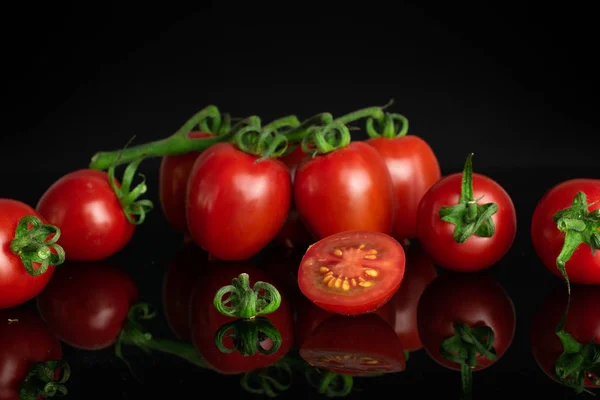 Red cherry tomato isolated on black glass — Stock Photo, Image