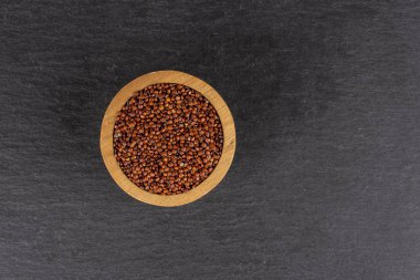 Gri taş üzerinde kırmızı Quinoa tohumları