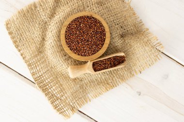 Gri ahşap üzerinde kırmızı Quinoa tohumları