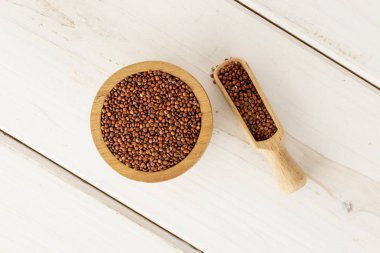 Gri ahşap üzerinde kırmızı Quinoa tohumları
