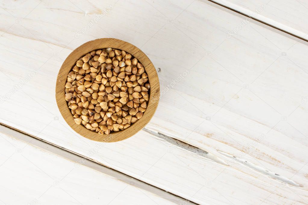 Raw buckwheat grain on grey wood