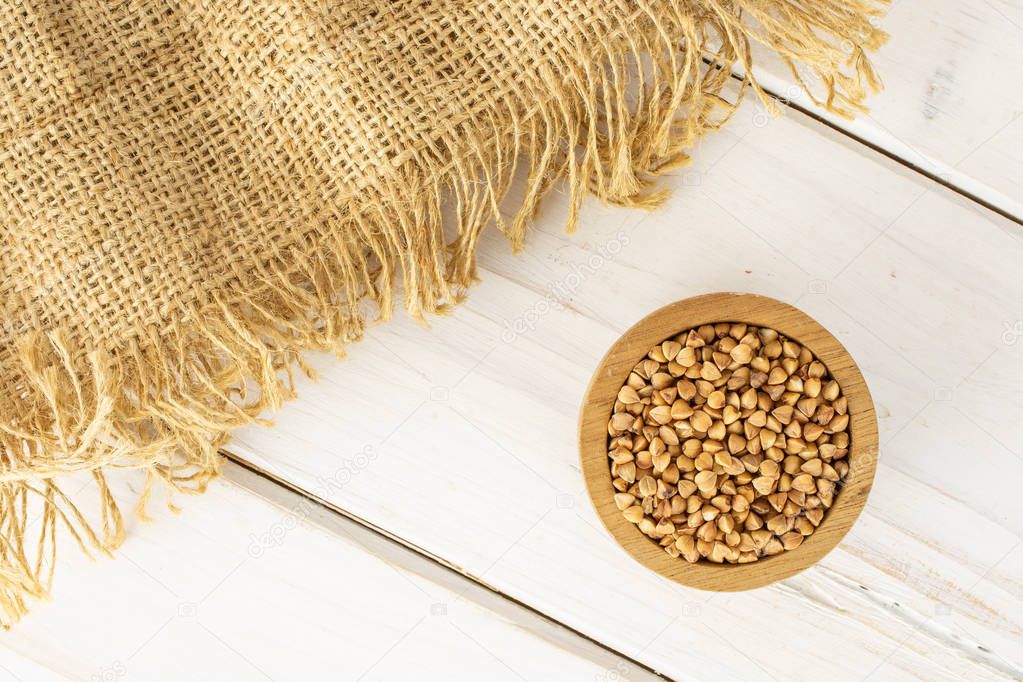 Raw buckwheat grain on grey wood