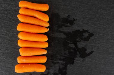 Gri taş üzerinde soyulmuş bebek havuç