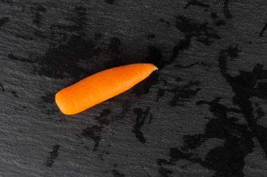 Gri taş üzerinde soyulmuş bebek havuç