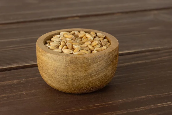 Пшеничное зерно Динкеля на коричневом дереве — стоковое фото