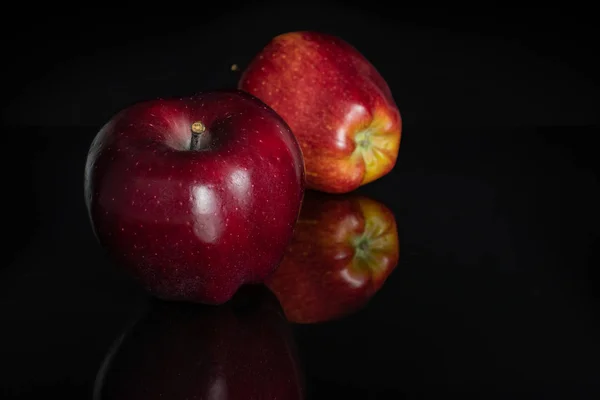 Яблоко красный вкусный изолирован на черном стекле — стоковое фото