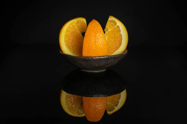 Sweet orange isolated on black glass — Stock Photo, Image