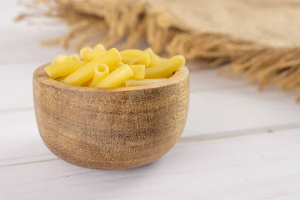 Rohe Makkaroni-Nudeln auf grauem Holz — Stockfoto