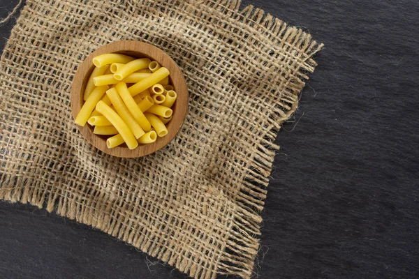 Raw macaroni pasta on grey stone — Stock Photo, Image