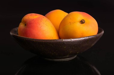 Siyah cam üzerinde izole taze turuncu kayısı