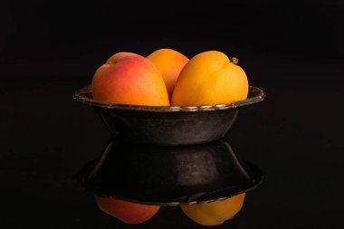 Siyah cam üzerinde izole taze turuncu kayısı