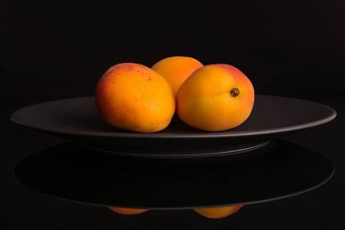 Siyah cam üzerinde izole taze turuncu kayısı