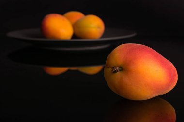 Siyah cam üzerinde izole taze turuncu kayısı