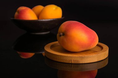 Siyah cam üzerinde izole taze turuncu kayısı