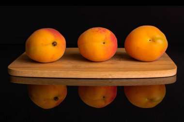 Siyah cam üzerinde izole taze turuncu kayısı