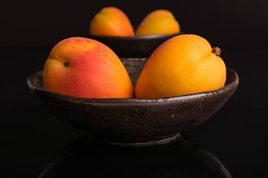 Siyah cam üzerinde izole taze turuncu kayısı