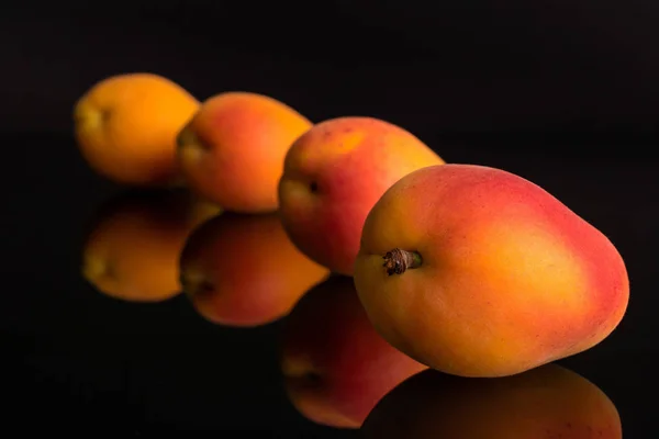 Alperce laranja fresco isolado em vidro preto — Fotografia de Stock