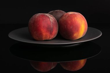 Siyah cam üzerinde izole taze kırmızı şeftali