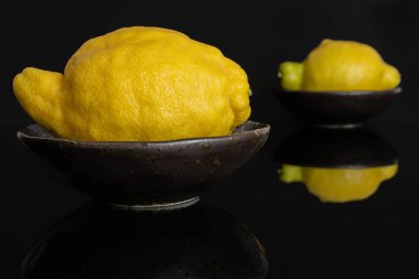 Siyah cam üzerinde izole taze sarı limon