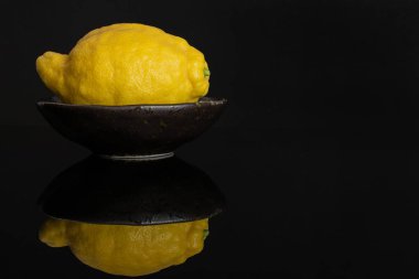 Siyah cam üzerinde izole taze sarı limon