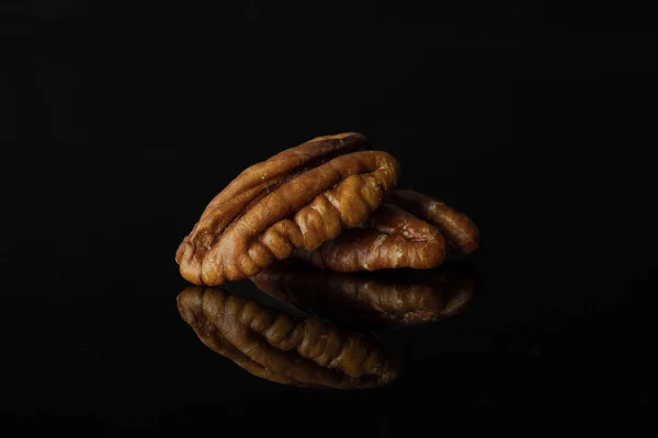 Verse Pecan moer geïsoleerd op zwart glas — Stockfoto