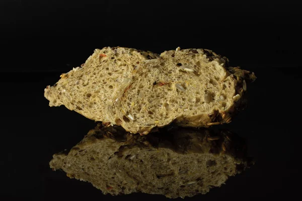Φρέσκια μπαγκέτα δημητριακών που απομονώνεται σε μαύρο γυαλί — Φωτογραφία Αρχείου