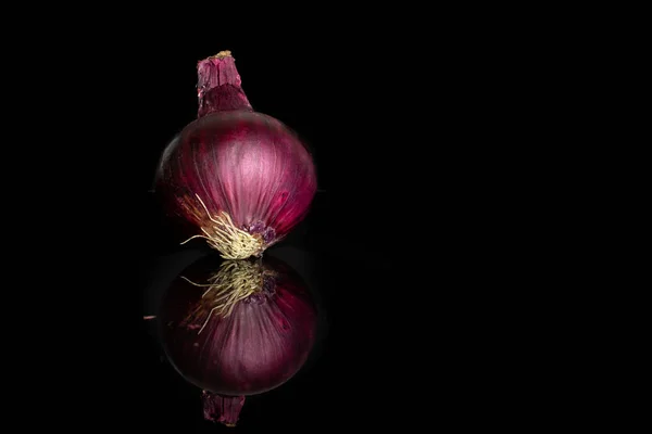 Inaktuell rödlök isolerad på svart glas — Stockfoto