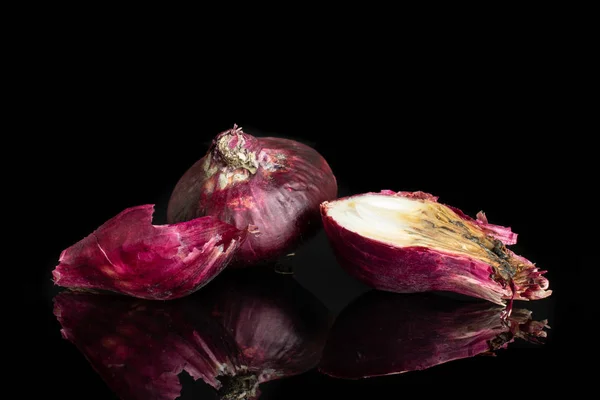 Stale red onion isolated on black glass