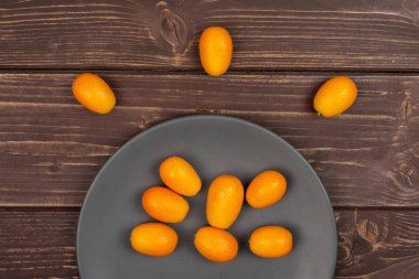 Kahverengi ahşap taze turuncu kumquat