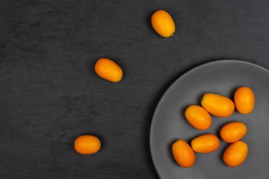 Gri taş üzerine taze turuncu kumquat