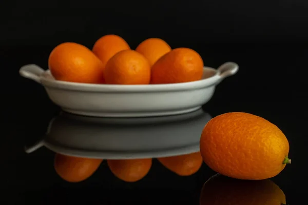 Świeży pomarańczowy kumkwat izolowane na czarnym szkle — Zdjęcie stockowe