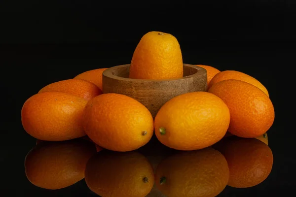 Φρέσκα πορτοκαλί κουμκουάτ απομονωμένα σε μαύρο γυαλί — Φωτογραφία Αρχείου