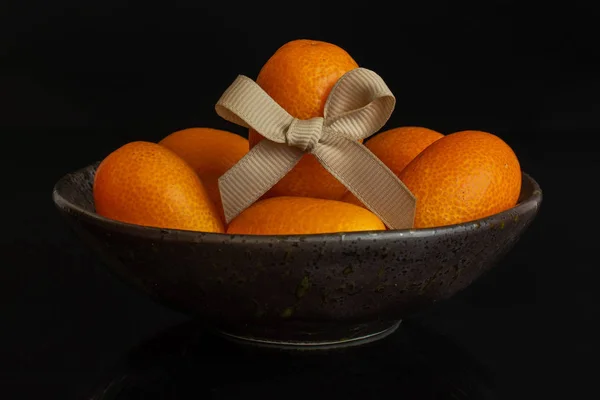 Fresh orange kumquat isolated on black glass — Stock Photo, Image