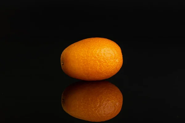 Fresh orange kumquat isolated on black glass — Stock Photo, Image