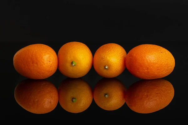 Kumquat naranja fresco aislado en vidrio negro — Foto de Stock